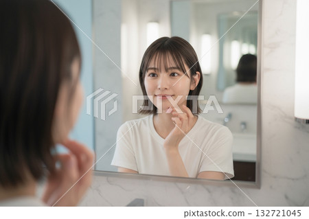 一個女人在鏡子前護膚 132721045