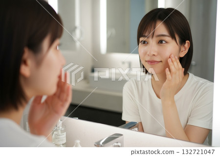 一個女人在鏡子前護膚 132721047
