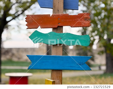 Colorful wooden arrows on post. Creativity, freedom, and joyful navigation concept Colorful wooden arrows on post. Creativity, freedom, and joyful navigation concept 132721529