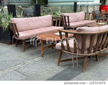 Outdoor cafe with wooden furniture. Relaxation, urban lifestyle, and social atmosphere captured through cozy design and street details. Outdoor cafe with wooden furniture. Relaxation, urban lifestyle, and social atmosphere captured through cozy design and street details. 132721674