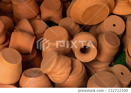 Stack of handmade terracotta clay pots in earthy tones, showing natural surface texture and craftsmanship. Craft pottery tradition, ceramic texture, rustic minimalism 132722200