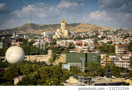 Panoramic View Of Tbilisi With Holy Trinity Cathedral And City Skyline Under Blue Sky: Urban Landscape Of The Georgian Capital Surrounded By Hills And Greenery Panoramic View Of Tbilisi With Holy Trinity Cathedral And City Skyline Under Blue Sky: Urban Landscape Of The Georgian Capital Surrounded By Hills And Greenery 132722599