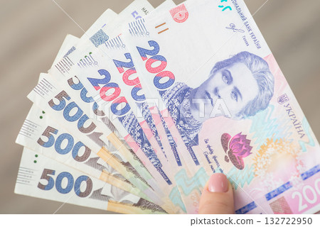 Fan of ukrainian banknotes in 200 and 500 hryvnia nominals in female hand, close up. Money of Ukraine, wealthy and successful life, purchases concept Fan of ukrainian banknotes in 200 and 500 hryvnia nominals in female hand, close up. Money of Ukraine, wealthy and successful life, purchases concept 132722950