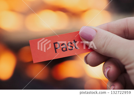 Small red sheet of paper in female hand with word "past" on it. Release from pain, mistakes and problems of the past 132722959