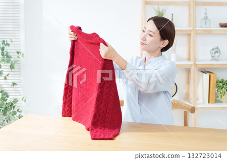 A woman taking out a sweater for a change of clothes A woman taking out a sweater for a change of clothes 132723014