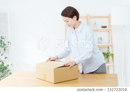 A woman packing in a cardboard box 132723019