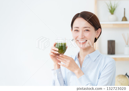 A woman drinking green juice A woman drinking green juice 132723020