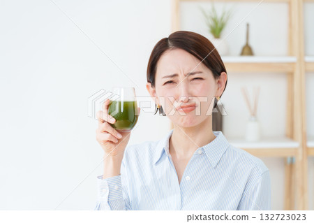 A woman drinking green juice A woman drinking green juice 132723023