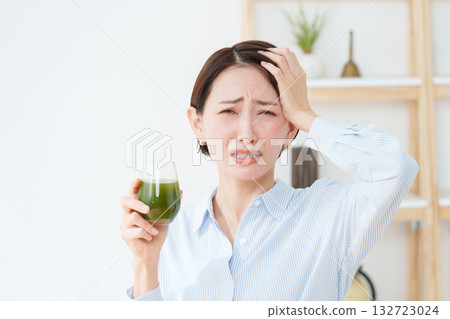 A woman drinking green juice A woman drinking green juice 132723024