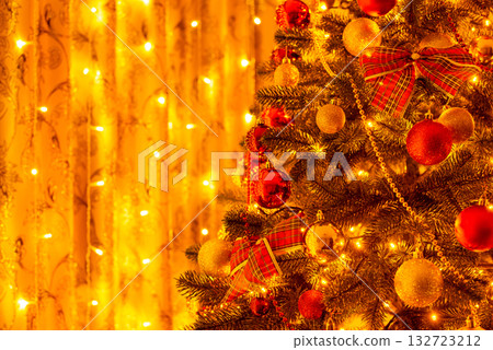 Close-up shot of Christmas tree decorated with many baubles, bows, beads. Christmas tree copy space, warm bright light 132723212