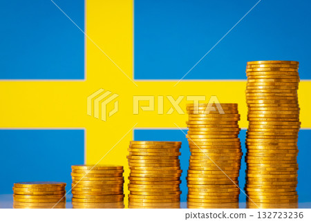 Flag of Sweden behind stacks of golden coins. Financial development of the country Flag of Sweden behind stacks of golden coins. Financial development of the country 132723236
