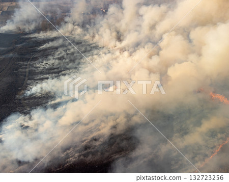 Clouds of smoke exhaling from burning grass and trees in countryside, polluting the air with smoke. Wildfire concept Clouds of smoke exhaling from burning grass and trees in countryside, polluting the air with smoke. Wildfire concept 132723256