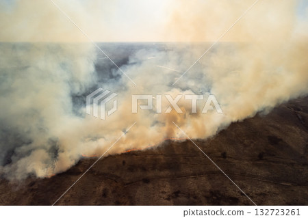 Aerial photo of wildfire burning dry grass in field. Dangerous fire in countryside 132723261