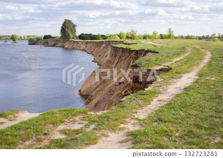 Landslide of bank of river, dangerous road near river. 132723281
