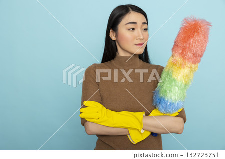 Pretty female janitor wearing yellow rubber gloves and standing with feather duster, prepared for cleaning services. Portrait of asian housekeeper posing with arms crossed, confident in completing Pretty female janitor wearing yellow rubber gloves and standing with feather duster, prepared for cleaning services. Portrait of asian housekeeper posing with arms crossed, confident in completing 132723751
