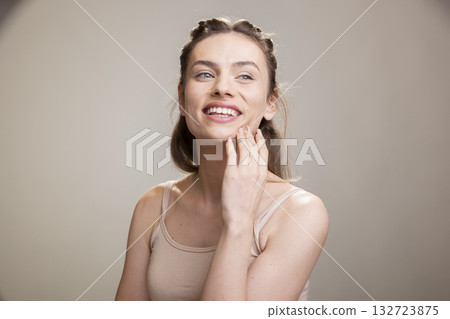 Portrait of feminine skincare model with a candid smile and smooth skin, looking happy and empowered in a beauty advertisement with natural makeup. Showcasing authenticity and self love. 132723875