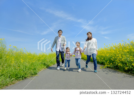 Four people walking on the promenade of rape blossoms Four people walking on the promenade of rape blossoms 132724452
