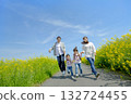 Four people walking on the promenade of rape blossoms 132724455