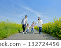 Four people walking on the promenade of rape blossoms 132724456