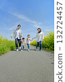 Four people walking on the promenade of rape blossoms 132724457