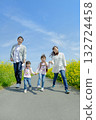 Four people walking on the promenade of rape blossoms 132724458