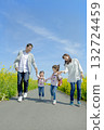 Four people walking on the promenade of rape blossoms 132724459