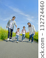 Four people walking on the promenade of rape blossoms 132724460
