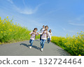 Four people walking on the promenade of rape blossoms 132724464
