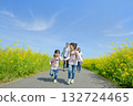 Four people walking on the promenade of rape blossoms 132724465