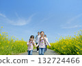 Four people walking on the promenade of rape blossoms 132724466