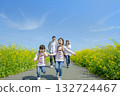 Four people walking on the promenade of rape blossoms 132724467