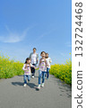 Four people walking on the promenade of rape blossoms 132724468