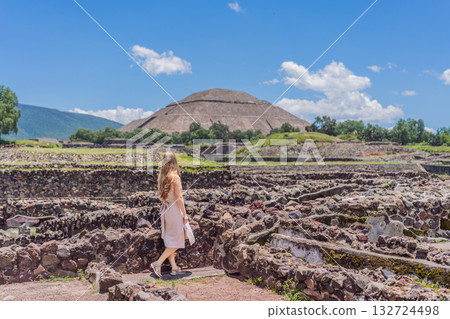 Female tourist standing in front of Teotihuacan pyramids in Mexico, enjoying sightseeing, adventure, and cultural heritage. Travel, tourism, and exploration concept Female tourist standing in front of Teotihuacan pyramids in Mexico, enjoying sightseeing, adventure, and cultural heritage. Travel, tourism, and exploration concept 132724498