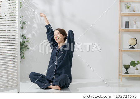 A woman in pajamas stretching A woman in pajamas stretching 132724555