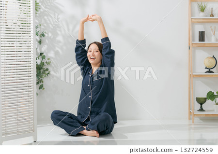 A woman in pajamas stretching A woman in pajamas stretching 132724559