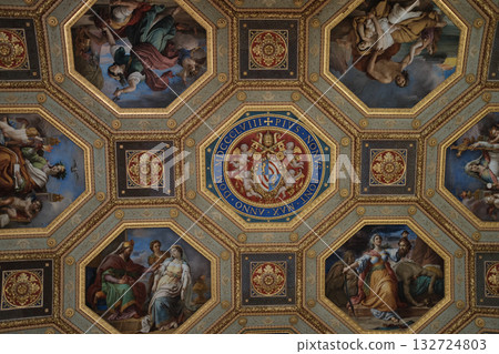Ornate coffered ceiling blue and gold octagons with painted medallions Vatican Museums interior rich decoration symmetric pattern no people. High quality photo 132724803