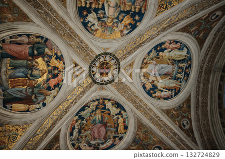 Ornate renaissance ceiling fresco with gilded coffers angels medallions and decorative borders museum interior Rome Italy cultural heritage rich colors no people vertical composition. High quality Ornate renaissance ceiling fresco with gilded coffers angels medallions and decorative borders museum interior Rome Italy cultural heritage rich colors no people vertical composition. High quality 132724829
