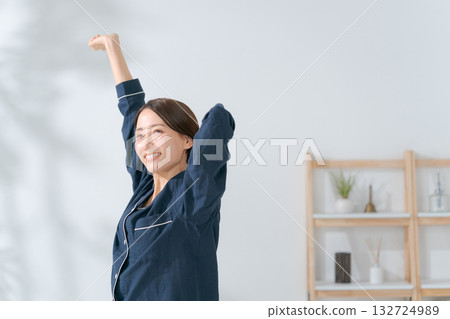 一個穿著睡衣的女人伸懶腰 132724989