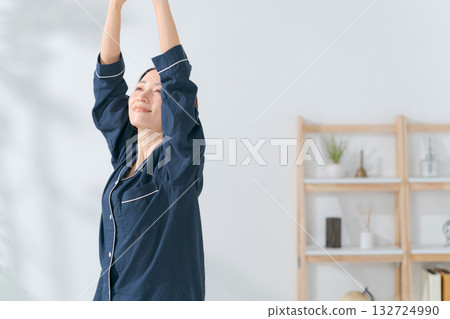 一個穿著睡衣的女人伸懶腰 132724990