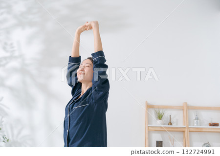 一個穿著睡衣的女人伸懶腰 132724991