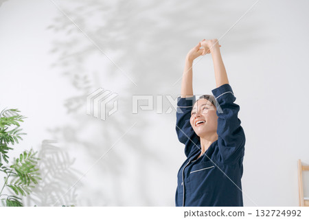 A woman in pajamas stretching 132724992