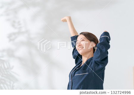 一個穿著睡衣的女人伸懶腰 一個穿著睡衣的女人伸懶腰 132724996