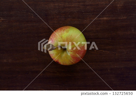 A top view of an unrelated apple on a table A top view of an unrelated apple on a table 132725650