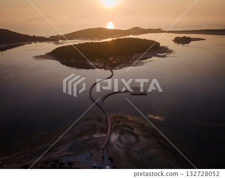 Aerial landscape photography. Fantastic morning view of St Mary's Monastery and wooden pier. Magnificent spring seascape of Narta Lagoon. Beautiful outdoor scene of Albania, Europe. Aerial landscape photography. Fantastic morning view of St Mary's Monastery and wooden pier. Magnificent spring seascape of Narta Lagoon. Beautiful outdoor scene of Albania, Europe. 132728052