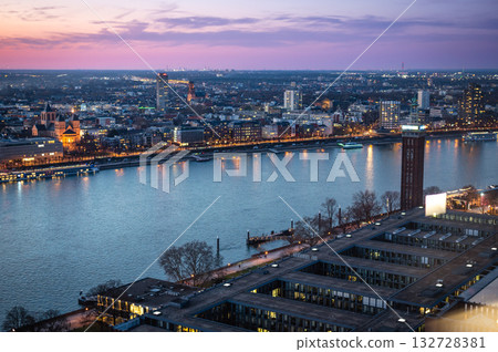 A breathtaking view of the Cologne skyline right after sunset featuring the iconic Cologne Cathedral and the city's famous bridge. The warm hues of the evening sky create a stunning scene in Germany. A breathtaking view of the Cologne skyline right after sunset featuring the iconic Cologne Cathedral and the city's famous bridge. The warm hues of the evening sky create a stunning scene in Germany. 132728381