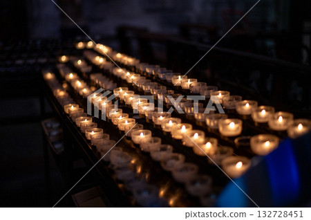 A serene scene of glowing candles inside Cologne Cathedral, Germany. 132728451
