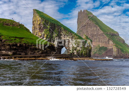 Close-up shot of famous Drangarnir cliff with Tindholmur islands in the background taken during early morning hike in spring at Faroese coastline Faroe Island, Denmark, Europe. High quality photo 132728549