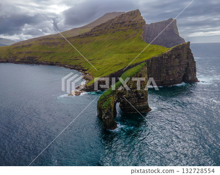 Close-up shot of famous Drangarnir cliff with Tindholmur islands in the background taken during early morning hike in spring at Faroese coastline Faroe Island, Denmark, Europe. High quality photo 132728554