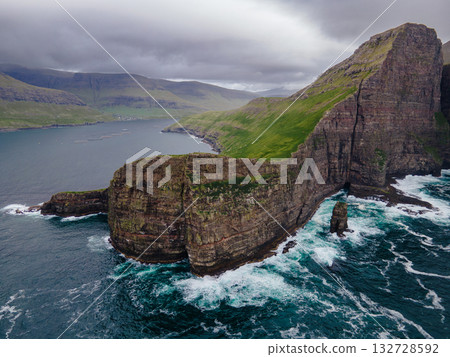 Close-up shot of famous Drangarnir cliff with Tindholmur islands in the background taken during early morning hike in spring at Faroese coastline Faroe Island, Denmark, Europe. High quality photo Close-up shot of famous Drangarnir cliff with Tindholmur islands in the background taken during early morning hike in spring at Faroese coastline Faroe Island, Denmark, Europe. High quality photo 132728592