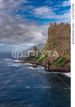 Close-up shot of famous Drangarnir cliff with Tindholmur islands in the background taken during early morning hike in spring at Faroese coastline Faroe Island, Denmark, Europe. High quality photo 132728596